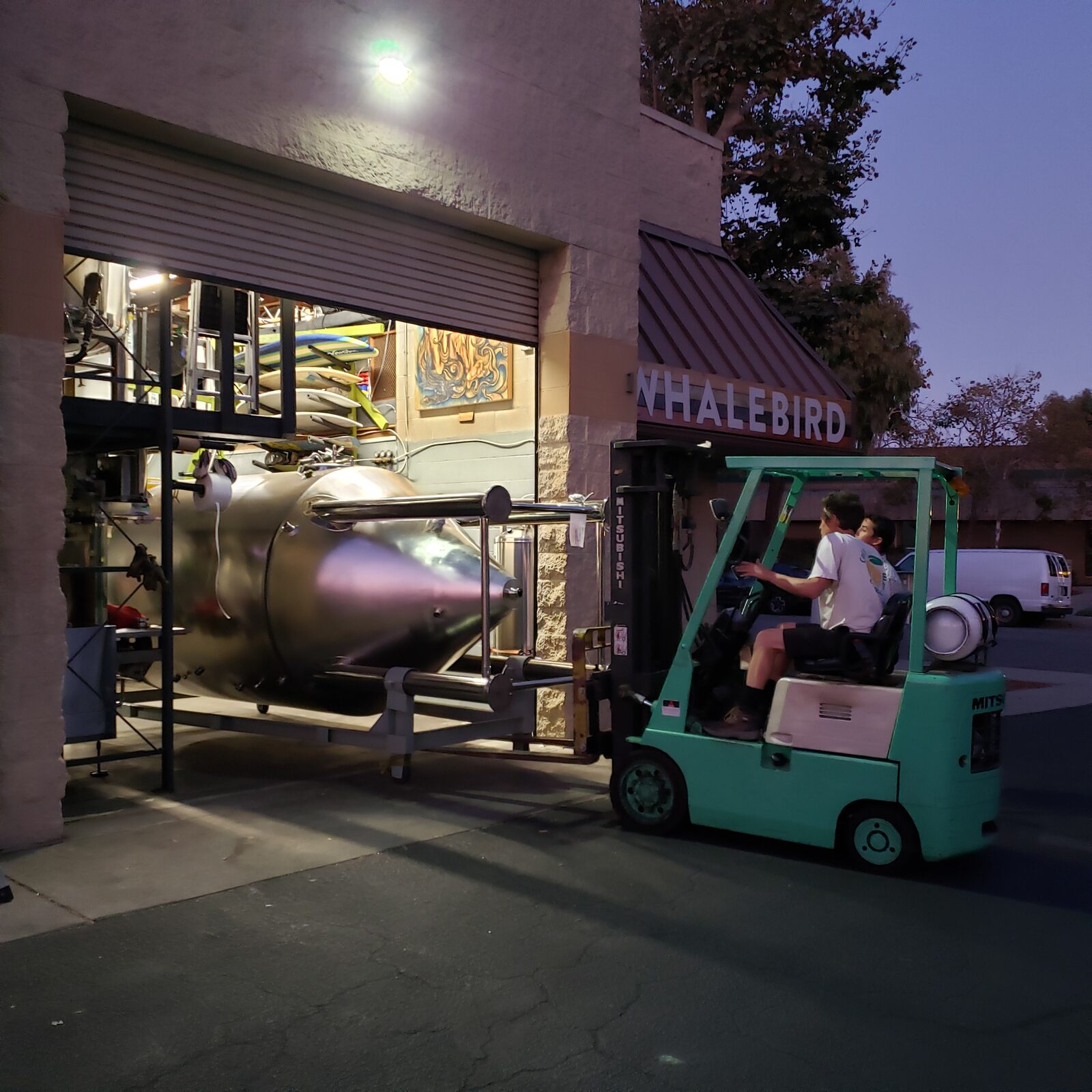 Forklift moving a tank in at dusk