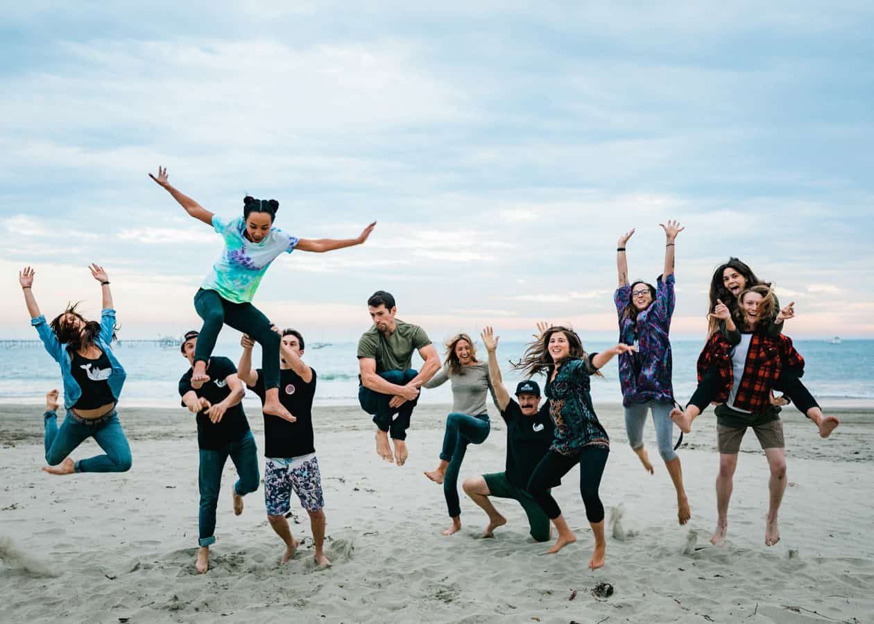 The Whalebird team jumping for a group photo on the beach