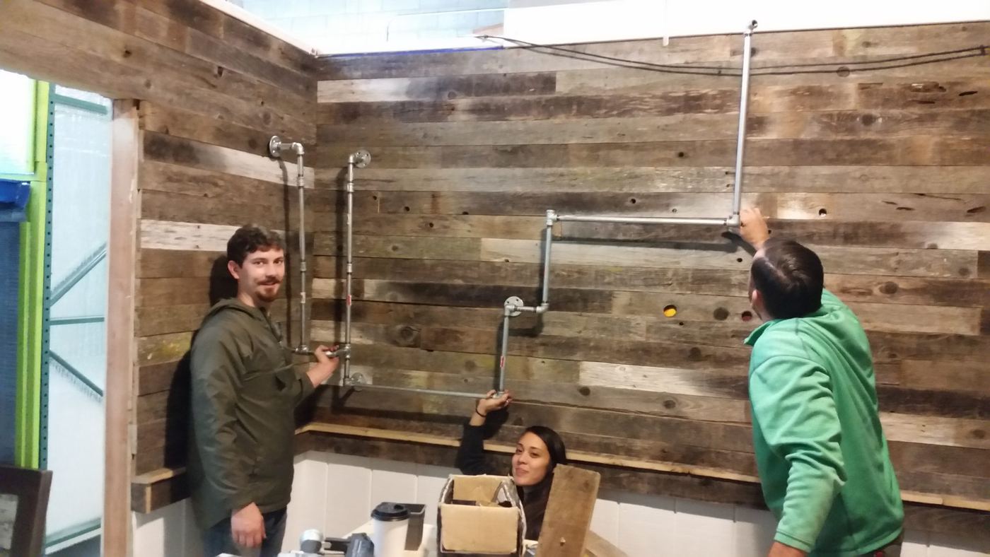 Mounting galvanized pipe shelving onto the reclaimed barn wood wall
