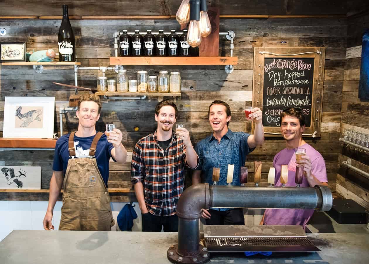 Four of us behind the finished bar raising a taster glass